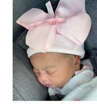 Baby Zema sleeping with large pink bow on her hat