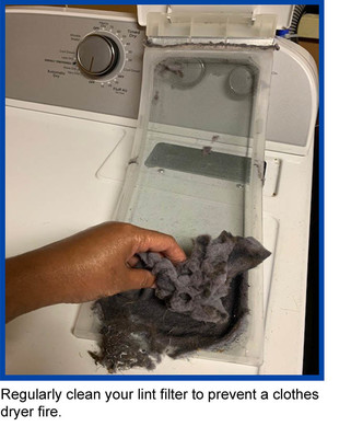 Hand removing lint in dryer - Regularly clean your lint filter to prevent a clothes dryer fire.