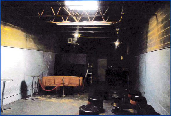 Illegal club closed by DPIE Enforcement inspectors. Pic of basement seating and dark-painted walls.