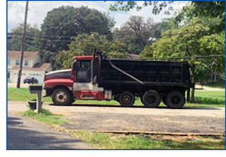 Commercial dump truck illegally parked in residential driveway