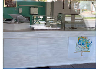 Cake Batter and Company bakery counter with cake logo displayed in the window