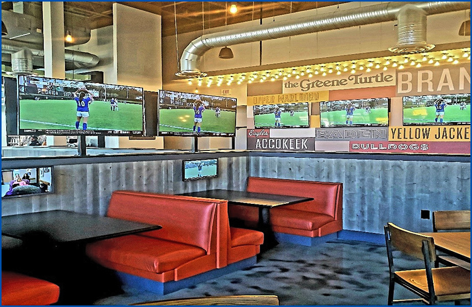 Interior of The Green Turtle Restaurant, showing multi-signs on wall and red booth benches