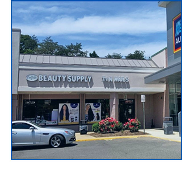 Envy Us Beauty Supply storefront in Ft. Washington, photo shows pretty bushes and parking lot.
