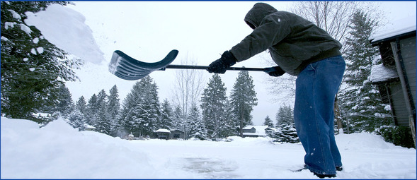 Shoveling snow, person clearing sidewalk, tossing snow off the shovel to the side.