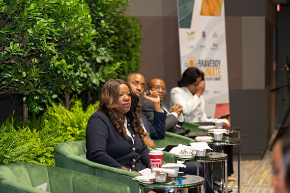 County Executive Braveboy sitting in green chair on stage looking into crowd in distance