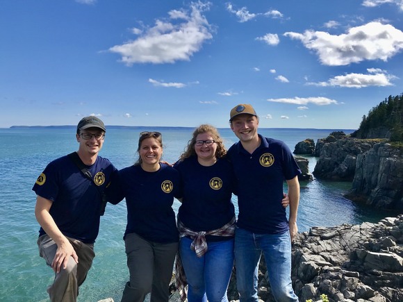 Group posing at the edge of the ocean