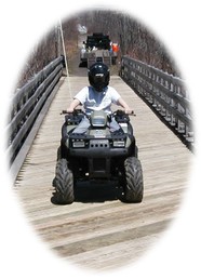 ATV rider crossing the Temple Stream bridge