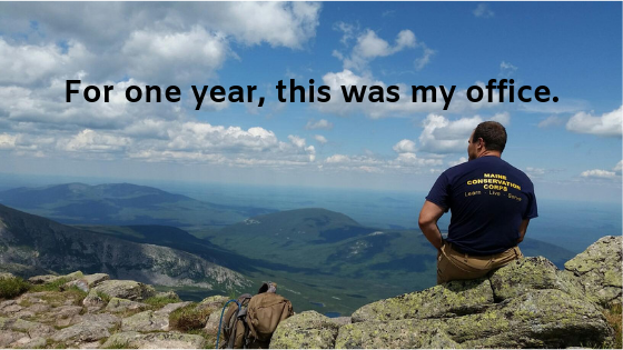 Team Member sitting looking out over mountains