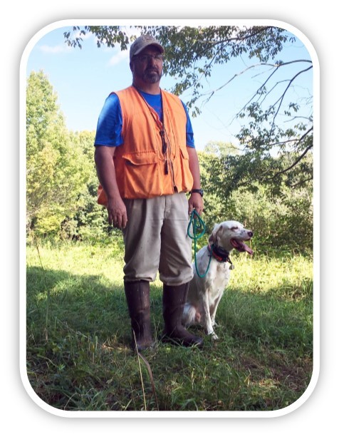 Dog on leash and sitting next to handler.