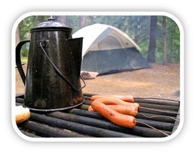 Coffee and hotdogs on the grill at a campsite