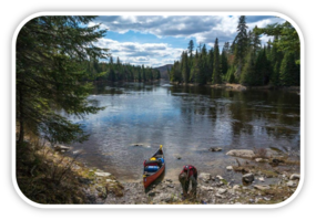 Allagash Wilderness Waterway with canoe and paddler in foreground.