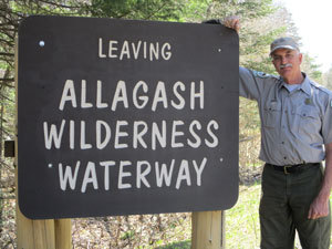 Leaving Allagash Wilderness Waterway sign with Matt LaRoche, AWW Superintendent, beside it.