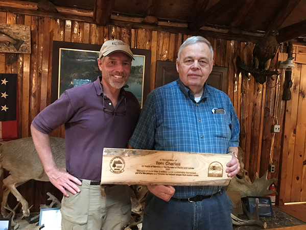 Photo of Tom Charles, BPL Chief of Silviculture receiving retirement plaque from BPL Director Andy Cutko.