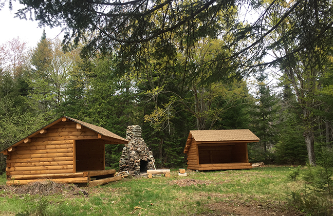 Adirondack shelters and stone fireplace at campsite along the Great Circle Trail at Nahmakanta Public Land.
