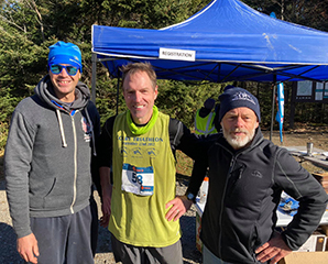 Bold Coast Runners Eric Mauricette (L) and John Hough (R) with Andy Cutko at event registration table.