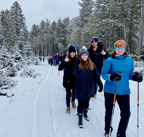 First Day Hikers 2020 on a forest trail with fresh powder snow in Lily Bay State Park.