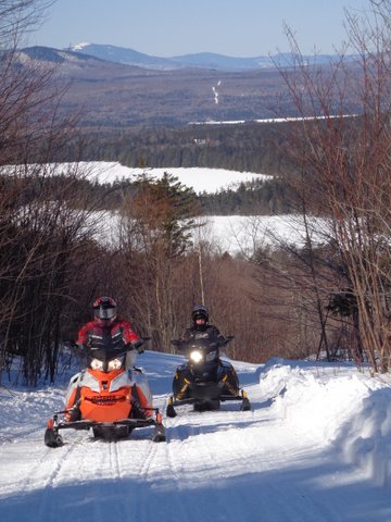 Snowmobile riders on the Jo Mary Trail in Maine's 100 Mile Wilderness near Moosehead Lake.