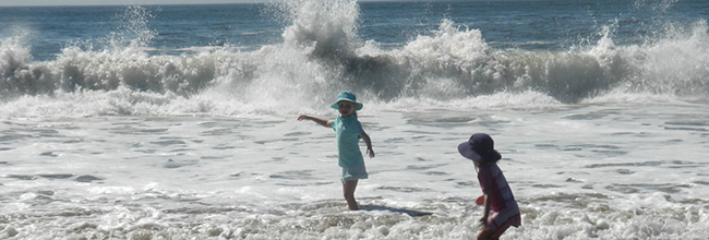 Two children playing in the surf on the beach at Reid State Park. Ellen Wood photo.