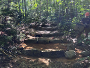 Newly constructed check steps, a stone and soil stairway, on the Brook Trail at Tumbledown Public Land.