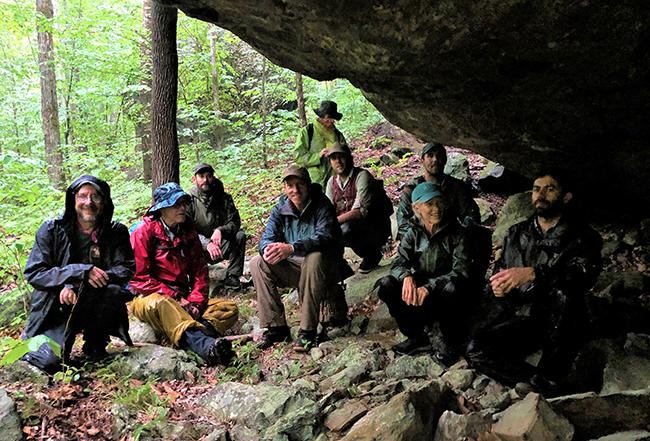 Ecological Reserves Scientific Advisory Committee at the Bigelow Reserve taking shelter under an overhanging boulder.