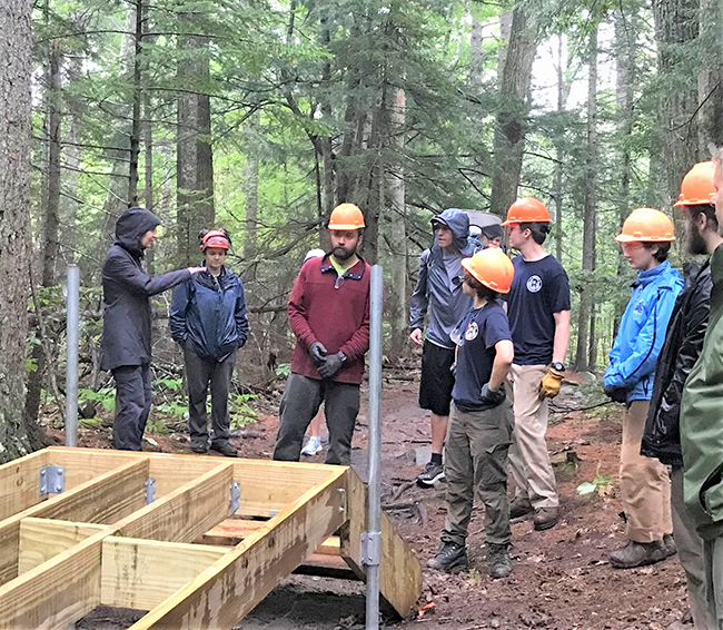 Commission Beal discussing a bog bridge with an MCC crew at Camden Hills State Park.