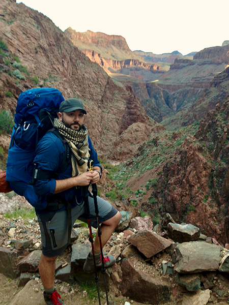 Mat Henion, the Bureau's new Outdoor Recreation Grants Specialist, hiking in a red cliff canyon.