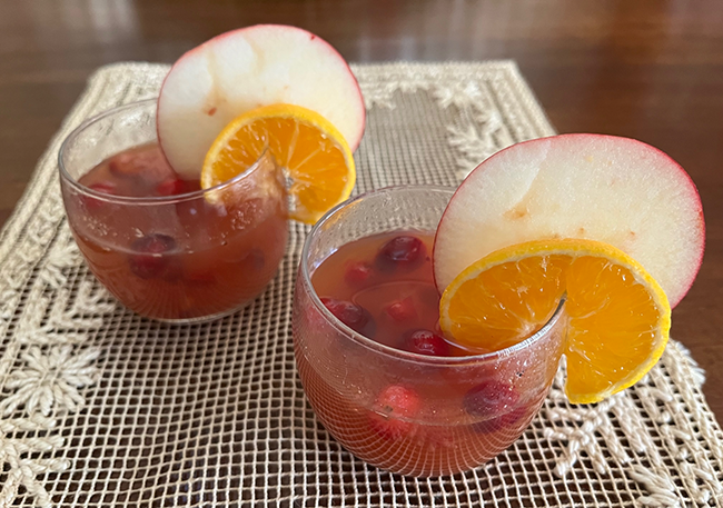 Hot spiced cider on a glass garnished with a slice of apple and slice of orange. Photo by Jocelyn Hubbell.