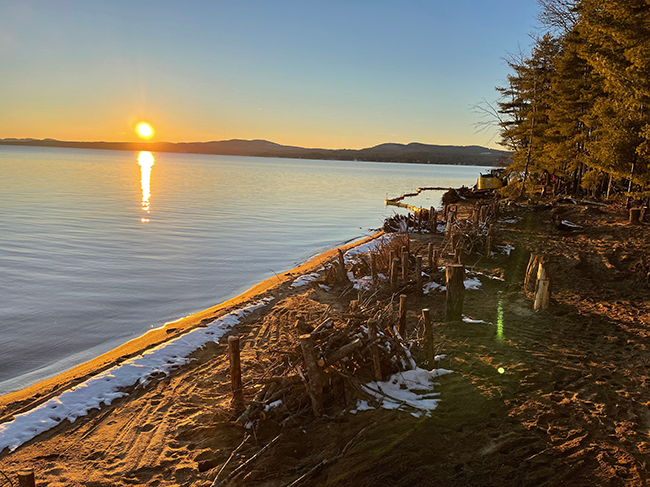 Shoreline restoration work at Sebago Lake State Park with a sunset over the lake in the background.