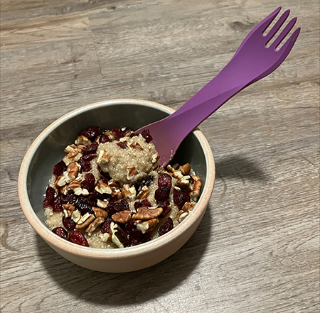 Bowl of homemade quinoa cereal with nuts and fruit.