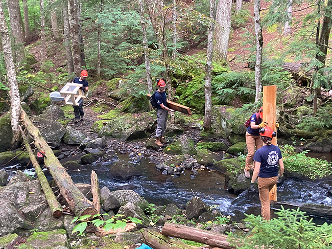 Maine Conservation Corps crew packing a "wet willy" into a Nahmakanta Public Land campsite.