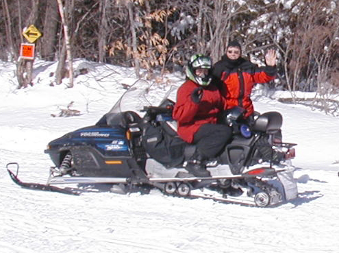 Sled riders taking a break on a snowmobile trail in the Moosehead area.