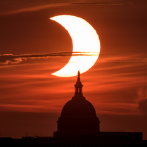 Partial solar eclipse on June 10, 2021 over the US Capitol from Arlington, Virginia. NASA/Bill Ingalls image.