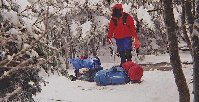 Winter camping at start of setup in a snowy wooded location.