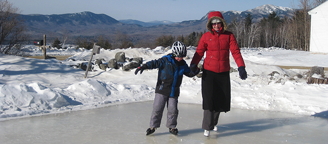 Ice rink at Mount Blue State Park with mountains in background.