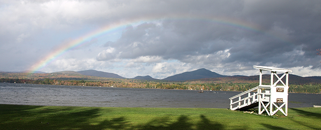 Webb Lake beach with a double rainbow above it. Mt. Blue State Park in Weld.