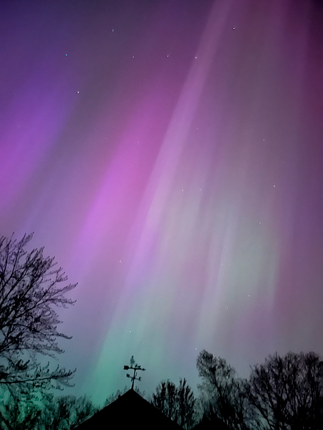 Aurora Borealis in Maine on May 10, 2024 glowing in purple, pink, and green. The stars at the top of the photo form the Big Dipper.