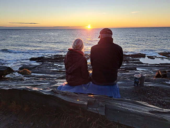 Couple enjoying the sunrise at a First Day Hike at Two Lights State Park, Maine.