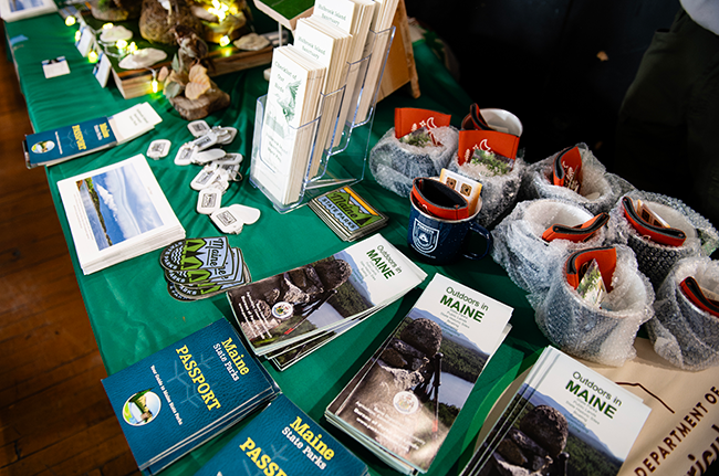 Table of information and giveaways at the 12/7/2024 Celtics game by Maine State Park staff.