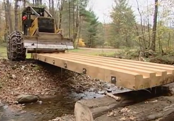 Skidder moving a temporary bridge