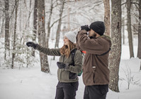 person looking through binoculars in the winter