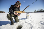man setting ice fishing trap