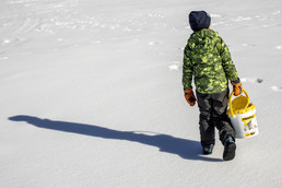 young child carrying bait bucket