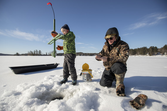 grandfather and grandson setting ice fishing traps