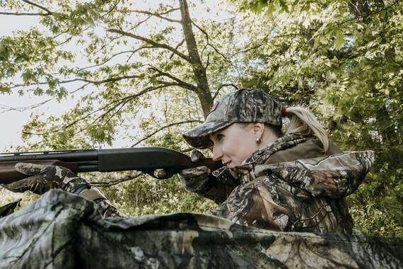 female turkey hunter shooting shotgun