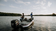 bass fishing boat with father and daughter fishing at sunset