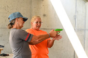 women showing another woman how to fire a handgun using a practice gun