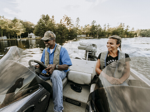 father and daughter smiling in bass boat driving to new fishing spot