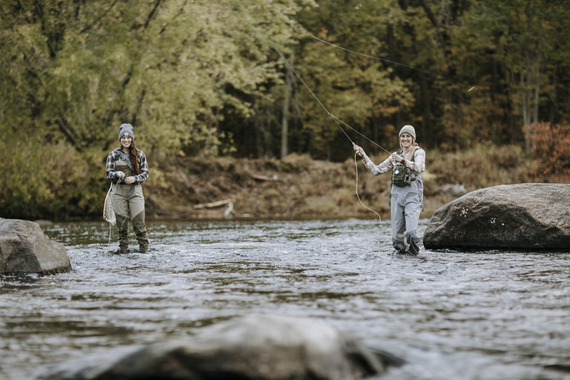 Two female fly anglers on a river at the start of fall