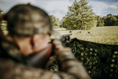 woman shooting a wild turkey in a field