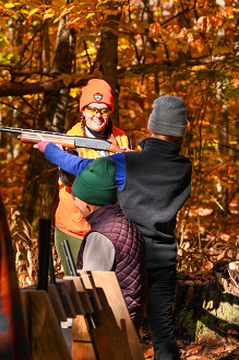 woman learning to shoot a shotgun